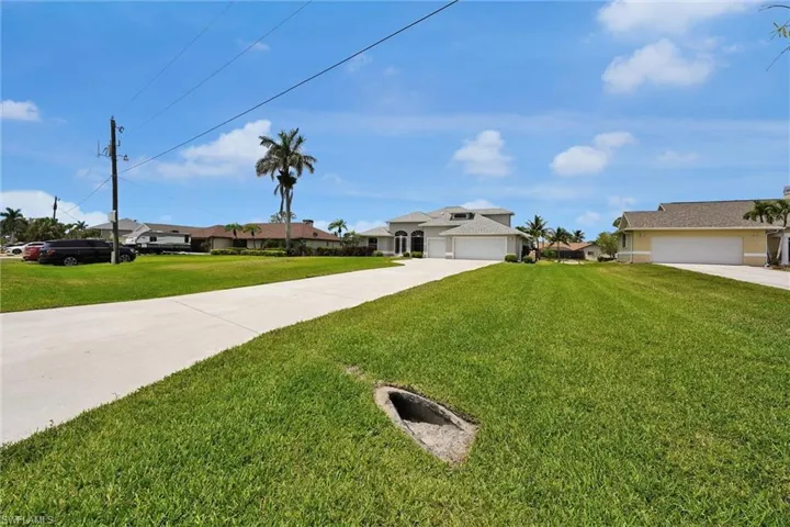 View of front facade with an attached garage, a front yard, a residential view, and driveway