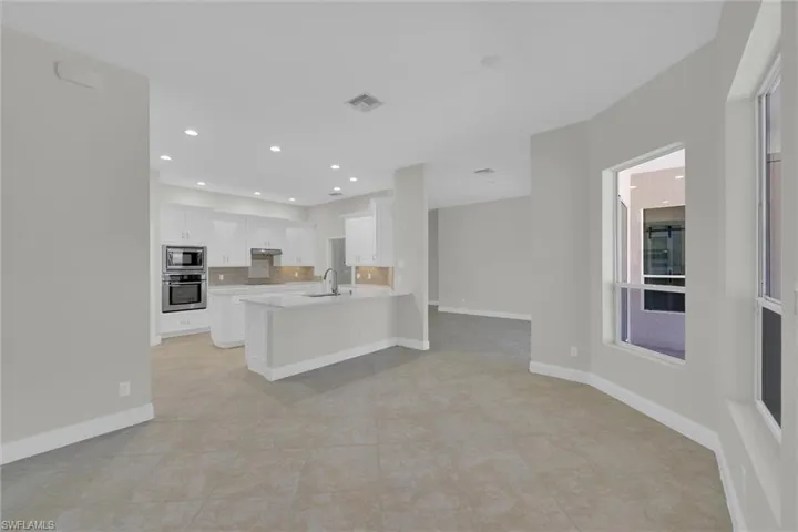 Kitchen with a sink, a peninsula, stainless steel appliances, visible vents, and light tile patterned floors