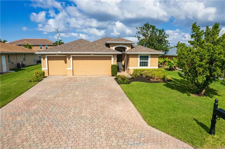 View of front of home featuring a garage, a front lawn, and central air condition unit