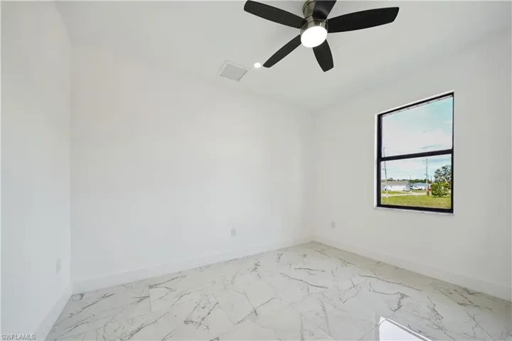 Empty room with baseboards, ceiling fan, and light marble finish floors