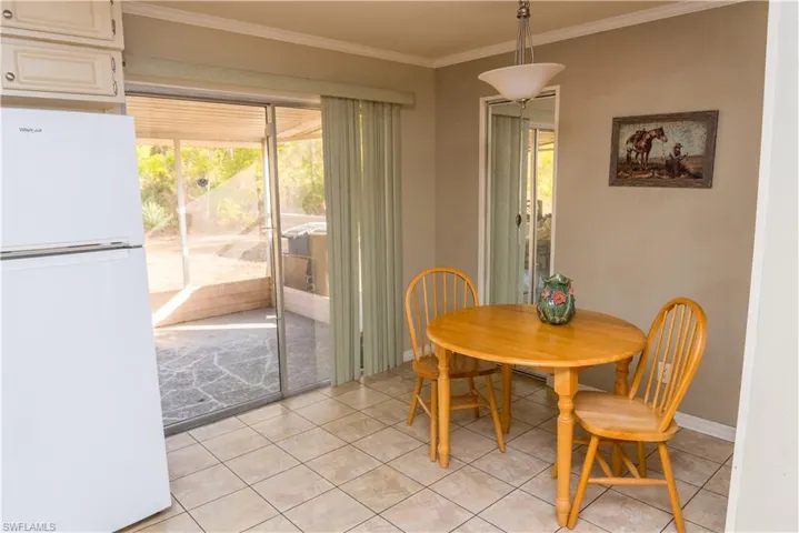 Dining space featuring ornamental molding, plenty of natural light, and light tile patterned flooring
