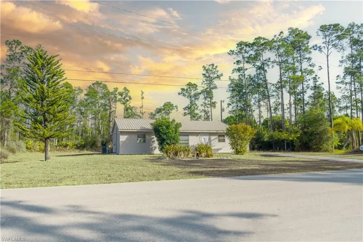View of front of house featuring a front lawn and a metal roof