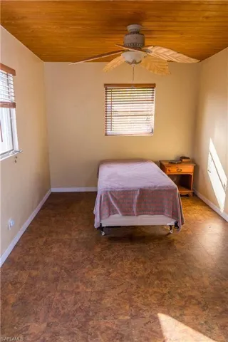 Bedroom with a ceiling fan and wooden ceiling