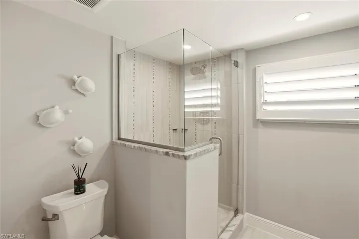 Full bath with a shower stall and recessed lighting