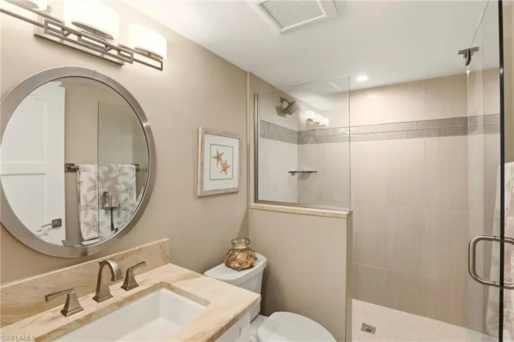 Bathroom featuring a stall shower and vanity