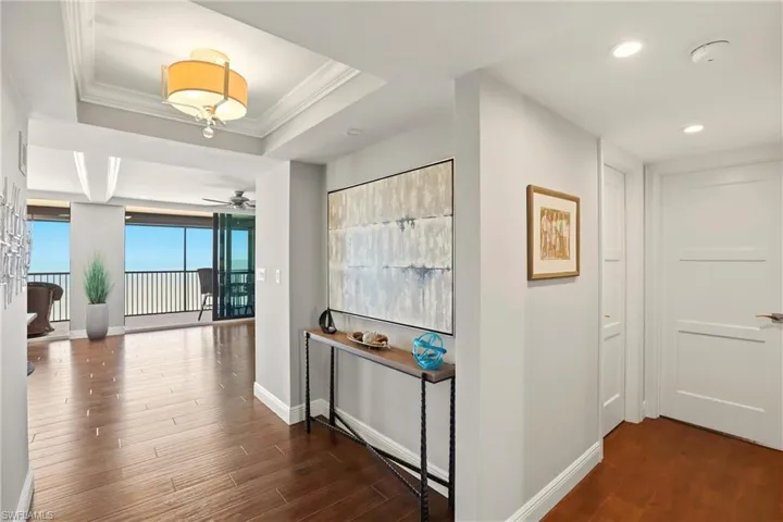 Hallway with dark wood-type flooring and ornamental molding