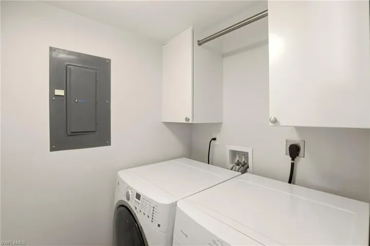 Laundry room with electric panel, cabinet space, and independent washer and dryer