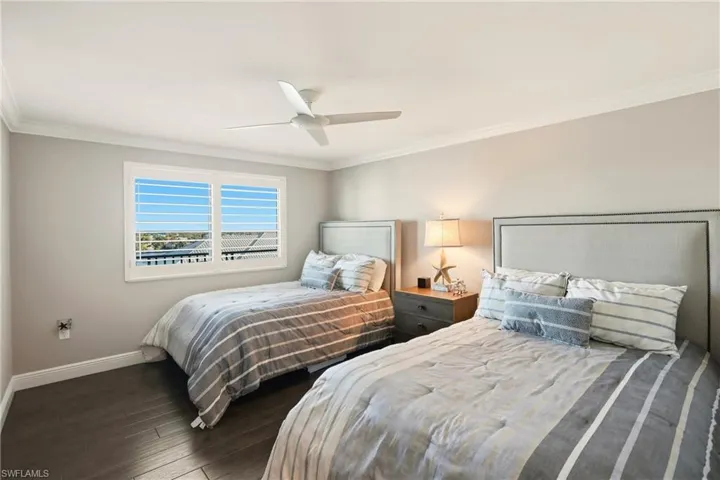Bedroom featuring crown molding, dark wood finished floors, and ceiling fan