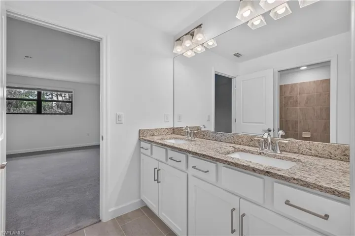 Dual vanity with light-toned granite countertop and undermount sinks
