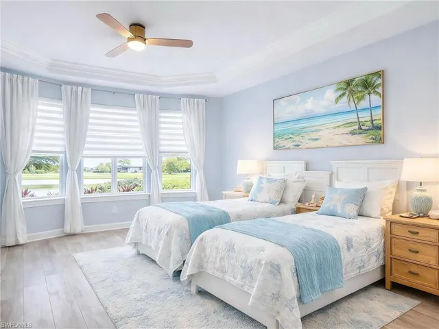 Bedroom with light wood finished floors, ceiling fan, and ornamental molding
