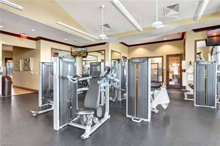 Gym with ornamental molding, recessed lighting, and vaulted ceiling