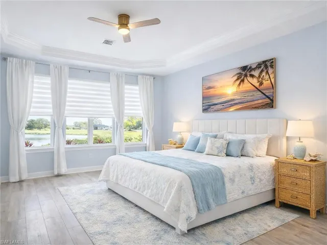 Bedroom with light wood-style floors, crown molding, and a ceiling fan