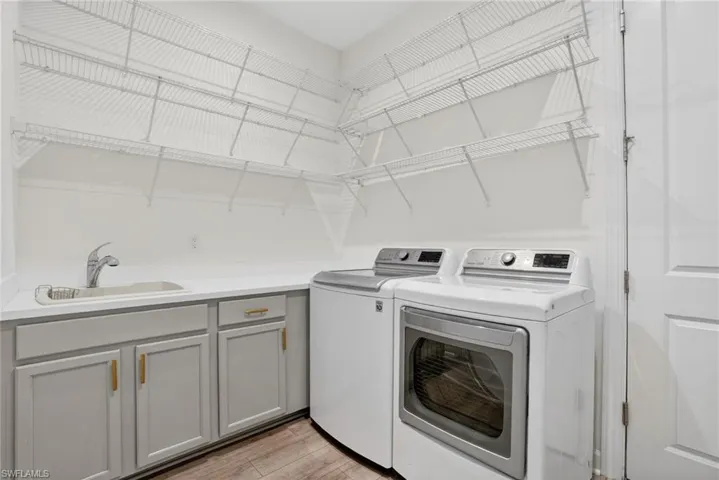 Laundry room with light wood finished floors and washing machine and dryer