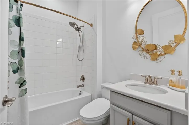 Bathroom with vanity and shower / tub combo with curtain