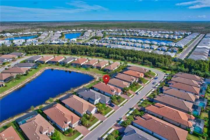 Aerial view of property and surrounding area with nearby suburban area and a nearby body of water
