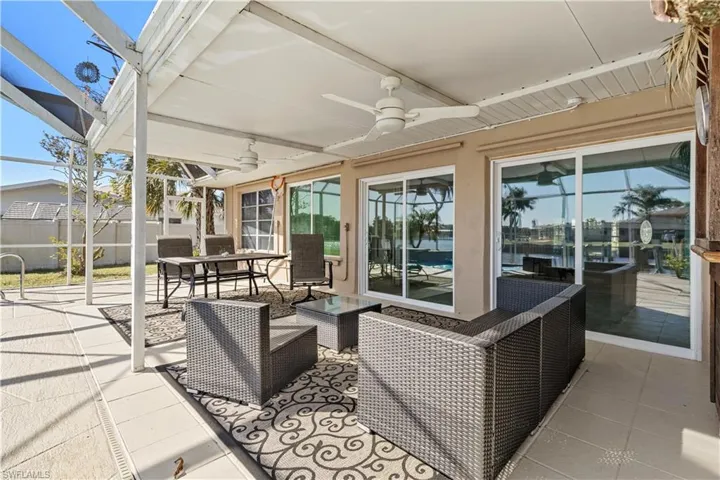 View of patio featuring an outdoor living space, ceiling fan, and a lanai