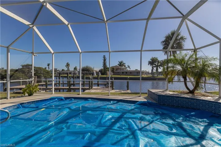 View of swimming pool featuring a water view and a lanai