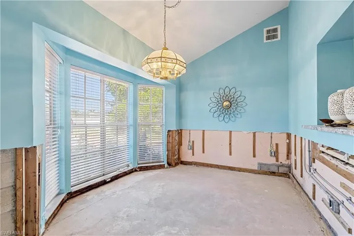 Unfurnished room with a chandelier and concrete flooring