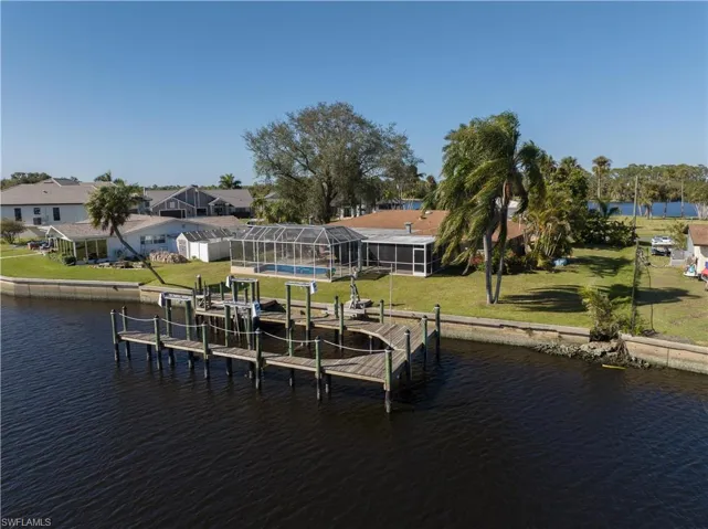 Dock area featuring glass enclosure, a yard, and a water view