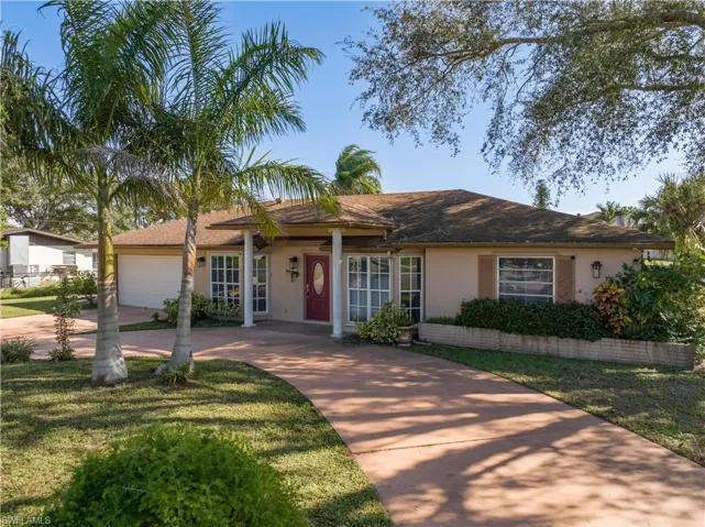 Ranch-style house with a garage and a front lawn
