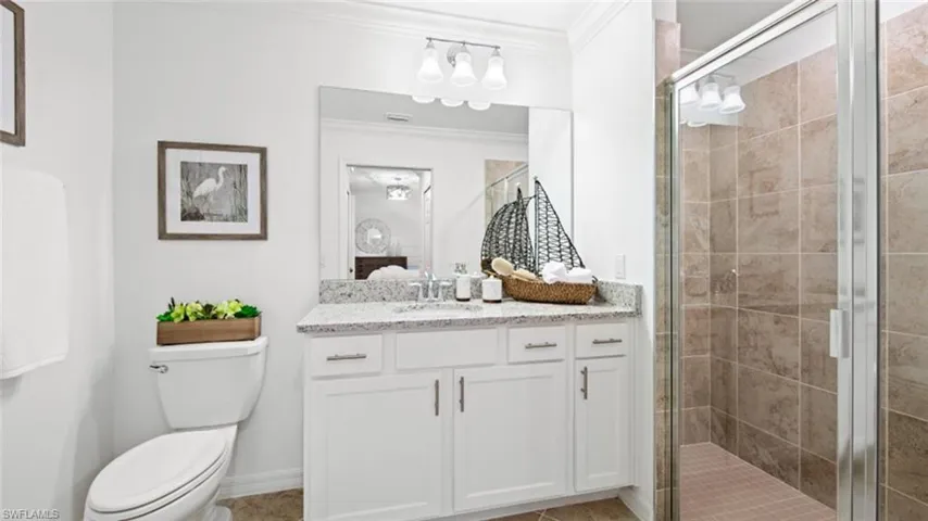 Bathroom featuring crown molding, toilet, an enclosed shower, and vanity
