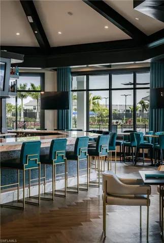 Bar with beamed ceiling, a community bar, and plenty of natural light