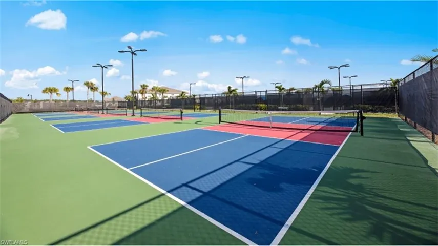View of tennis court featuring basketball hoop