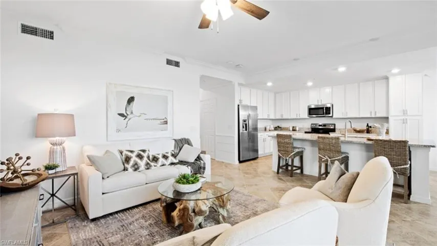 Living room with sink, ceiling fan, and ornamental molding