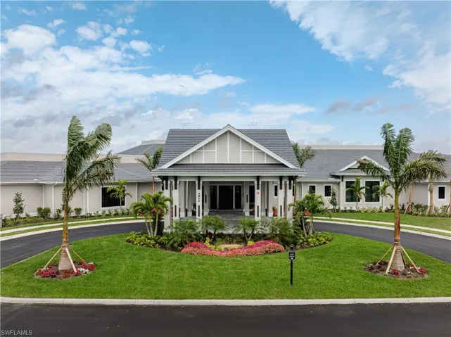 View of front facade featuring a front yard, curved driveway, and a porch