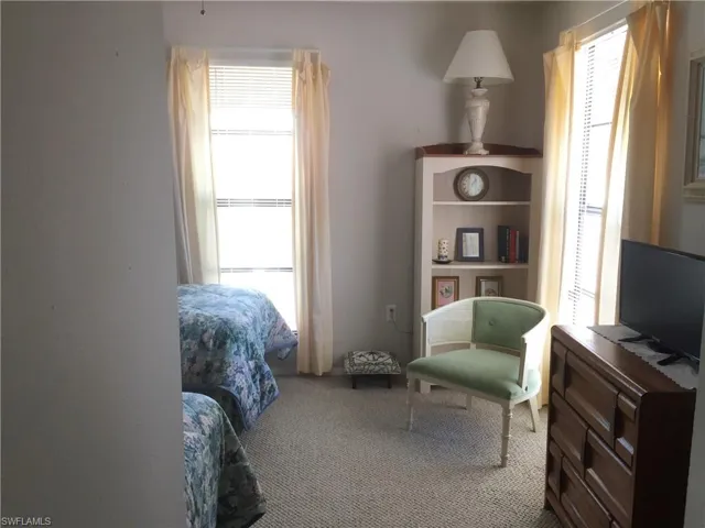 Spacious guest bedroom features 2 large windows for ample natural light and a view to the private courtyard.