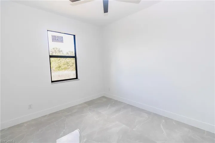 Unfurnished room with baseboards and a ceiling fan