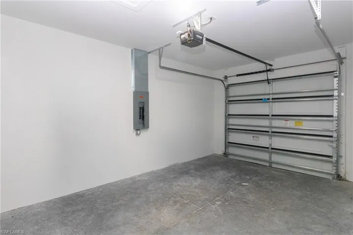 Garage featuring electric panel and a garage door opener