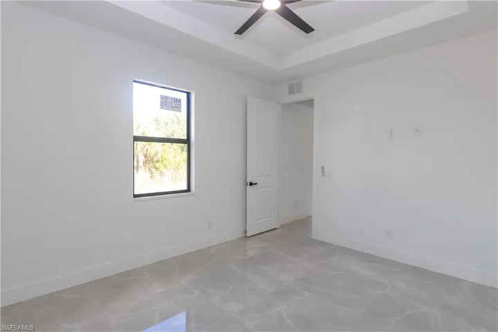Empty room with a tray ceiling and ceiling fan