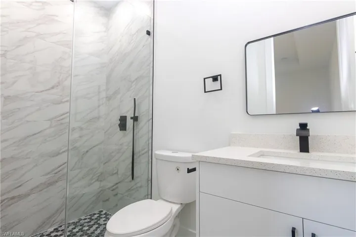 Bathroom with vanity and a marble finish shower