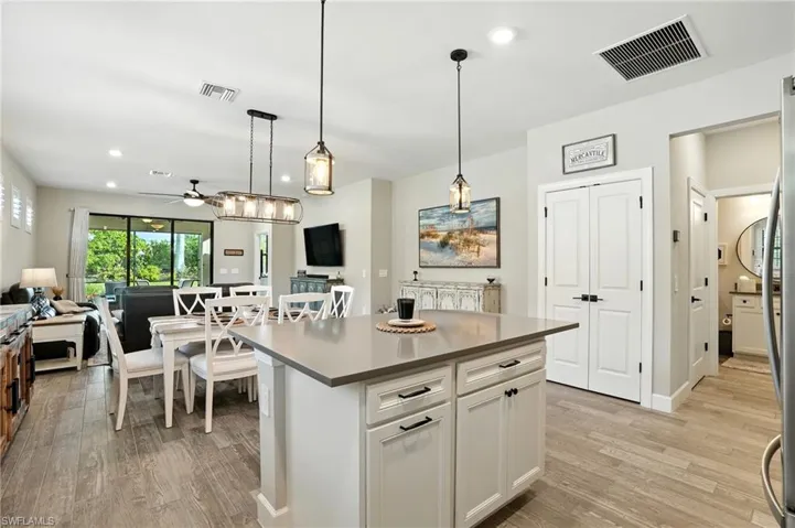Kitchen with open floor plan, pendant lighting, recessed lighting, light wood-style flooring, and a ceiling fan
