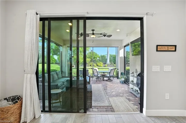 Doorway to outside with ceiling fan and wood finished floors