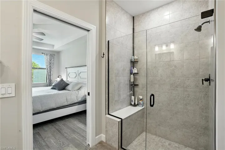 Bathroom with a shower stall, wood finished floors, and ensuite bathroom