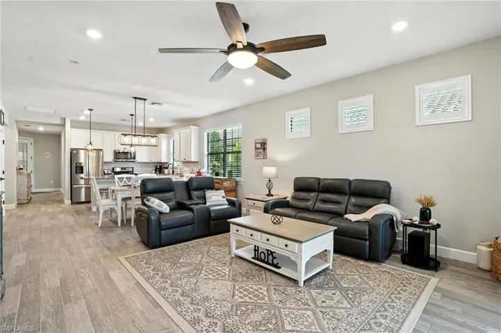 Living area with recessed lighting, ceiling fan, and light wood-style floors