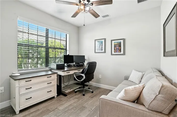 Office with light wood finished floors and ceiling fan