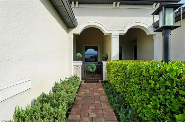 Property entrance featuring stucco siding and a gate
