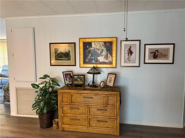 Room details featuring wood-type flooring, ornamental molding, and wooden walls