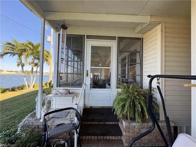Property entrance with a lawn and a water view