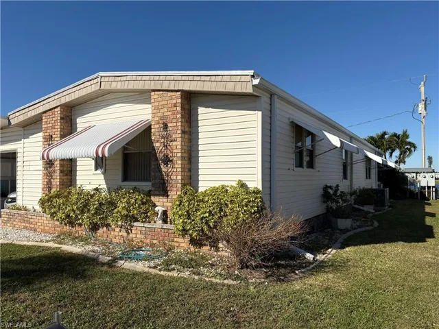 View of side of property featuring a lawn