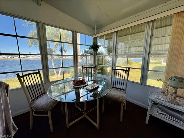 Sunroom with a water view, lofted ceiling, and a wealth of natural light