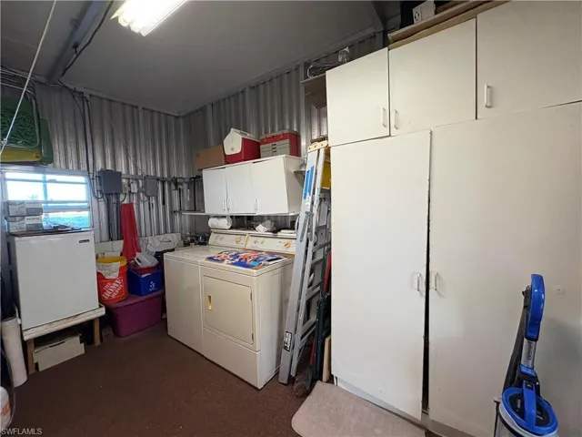Clothes washing area featuring cabinets and washing machine and clothes dryer