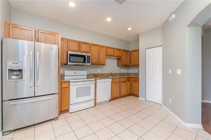 Kitchen with walk in pantry offering refrigerator, dishwasher, stove and microwave.