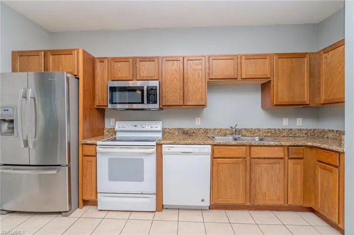 Kitchen with walk in pantry offering refrigerator, dishwasher, stove and microwave.