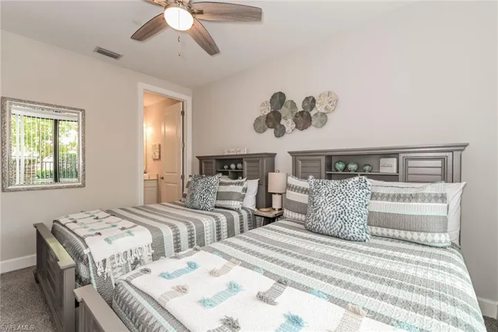 Carpeted bedroom featuring a ceiling fan and connected bathroom