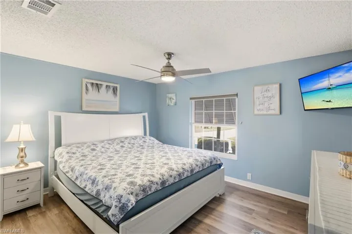 Bedroom featuring a textured ceiling, ceiling fan, and wood finished floors