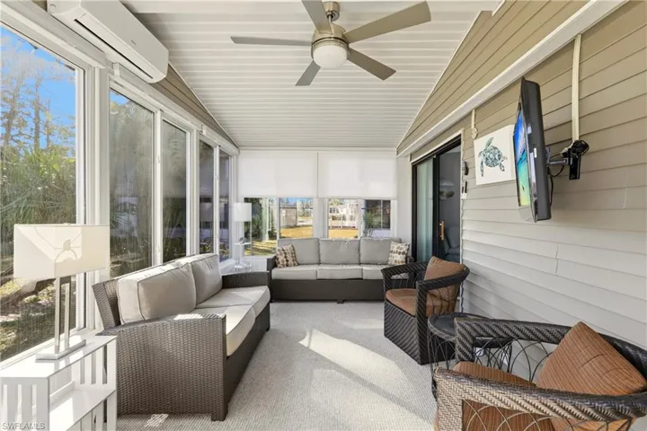 Sunroom featuring ceiling fan, an AC wall unit, and outdoor lounge area